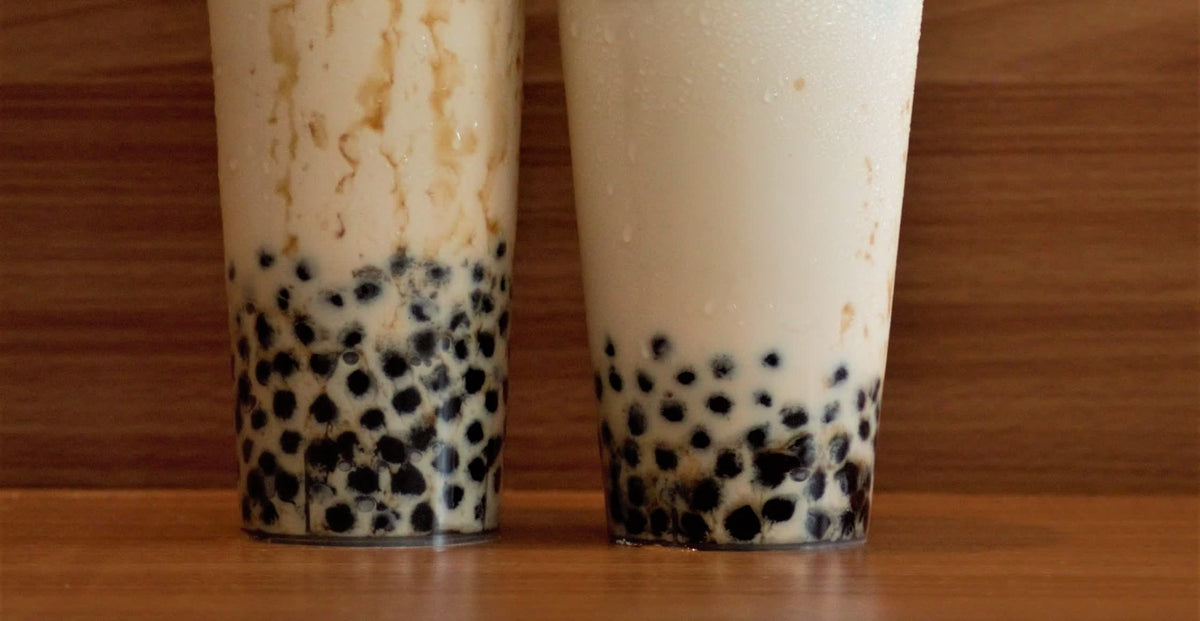 Two cups of brown sugar boba milk with tapioca pearls and brown sugar syrup streaks