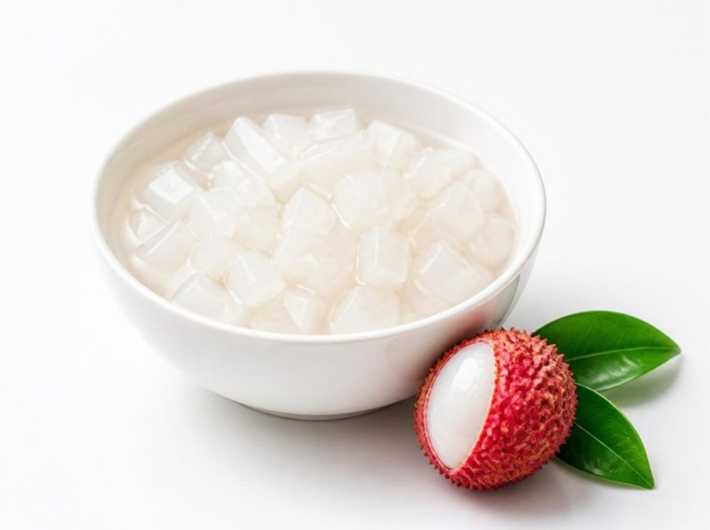 Bowl of lychee coconut jelly with a fresh lychee